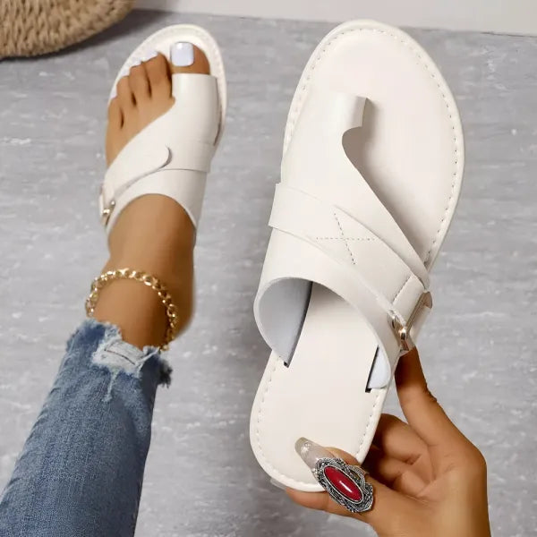 Model draagt zwarte leren orthopedische dames slippers, toont stijl en comfort perfect.
