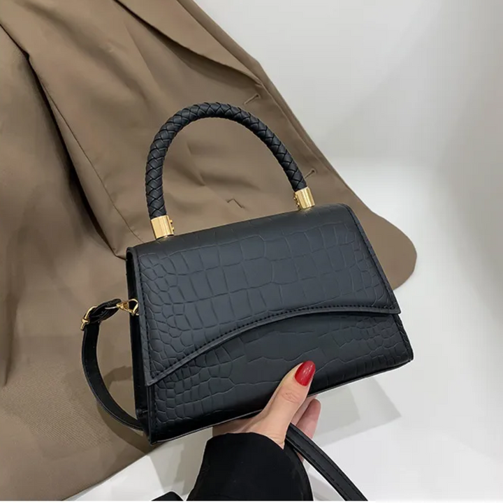 Zwarte PU leren dames handtas met elegant bovenhandvat. Stijlvol accessoire, ook als schouder- of crossbodytas.