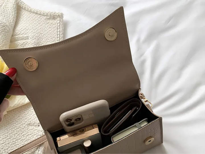 Khaki dames handtas van PU leer, met praktisch bovenhandvat en verstelbare riem voor schouder- of crossbodygebruik.