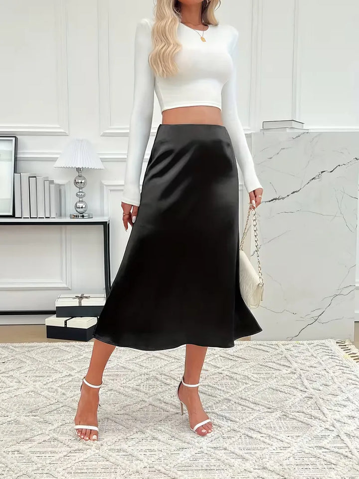 Champagnekleurige satijnen rok, elegante midi lengte, hoge taille, feestelijk.