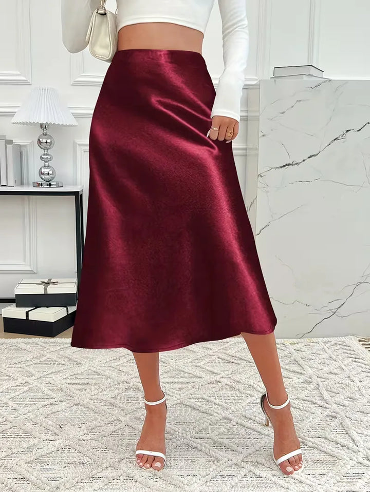 Zilverkleurige satijnen damesrok, hoge taille, perfect voor een avondje uit.