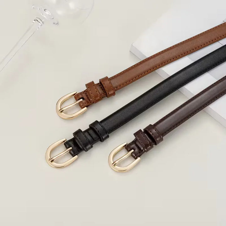 Dames accessoire: smalle zwarte riem met opvallende gouden gesp. Elegant en casual.