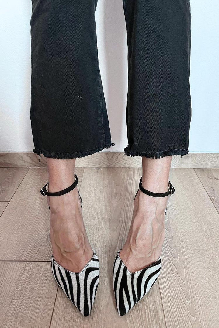 Modieuze damesschoenen: zwartwitte zebraprint pumps met hoge hakken en verstelbaar enkelbandje.